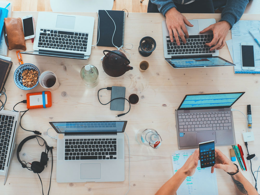 tavolo con freelance che lavorano con notebook e smartphone